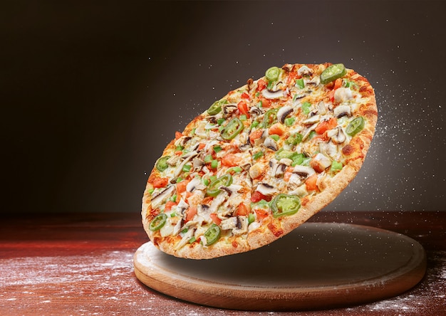Pizza classique sur une surface de table en bois sombre et un peu de farine. concept de menu de restaurant de pizza