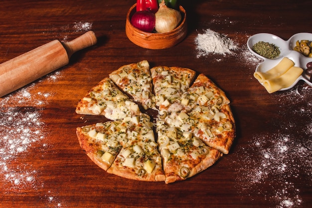 Pizza de coeurs de palmier coupés en morceaux sur une table en bois.