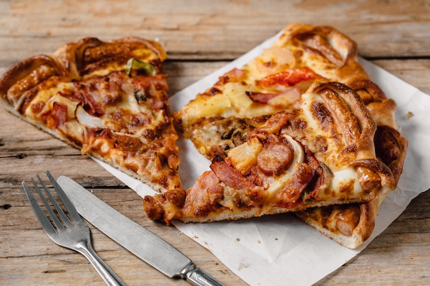 Pizza dans la boîte de papier sur la table en bois