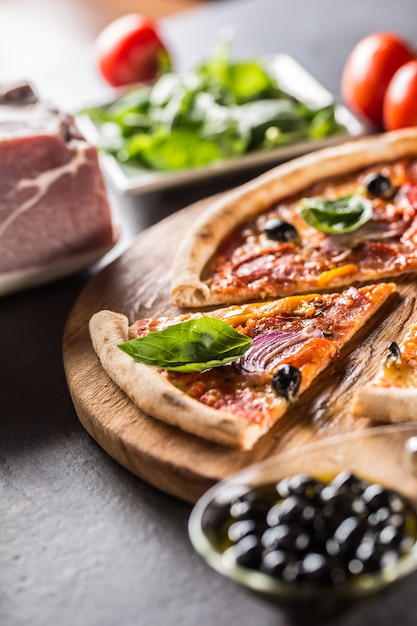 Pizza diavolo repas italien traditionnel de salami épicé peperoni piment oignon olives et basilic.