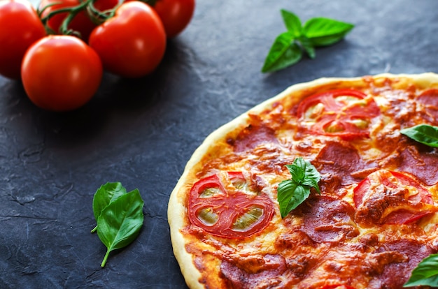 Pizza épicée maison avec saucisse et tomate.