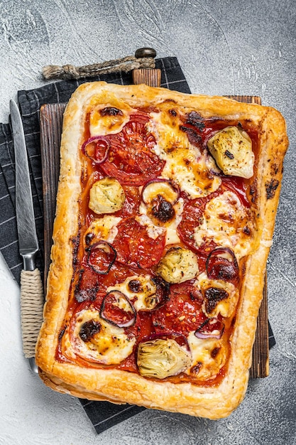 Pizza feuilletée végétarienne avec tomates mozzarella artichaut et fromage Fond blanc Vue de dessus