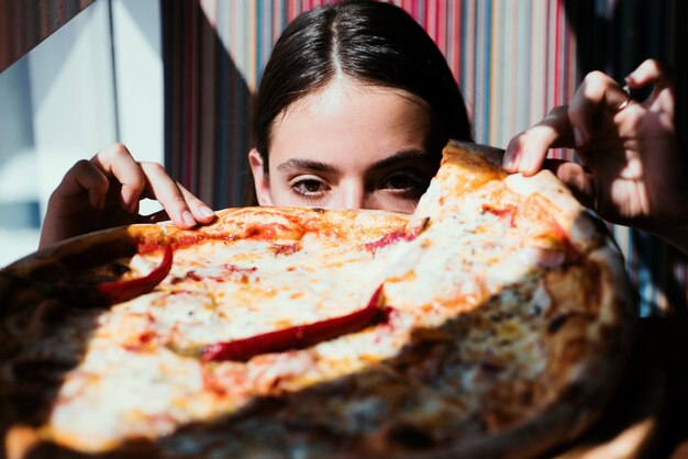 Pizza fille femme avec cuisine italienne au restaurant femme affamée