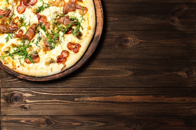 Pizza sur un fond de table en bois brun foncé