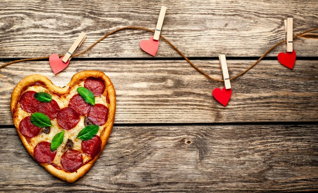 Pizza en forme de coeur sur une table en bois