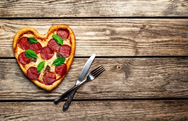 Pizza en forme de coeur sur une table en bois