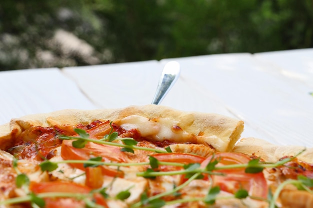 Pizza fraîche posée sur une table dans un café en plein air divisé en tranchesPhotographie en gros plan