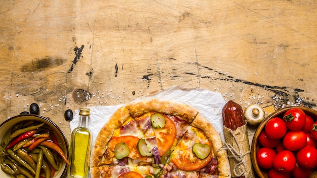 Pizza fraîche avec salami, tomates, poivre et huile d'olive.