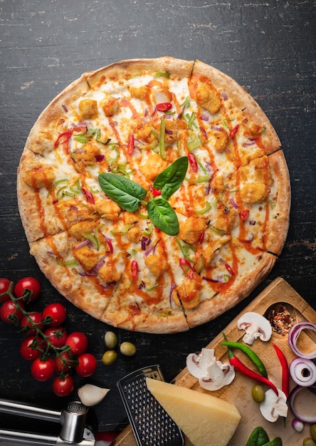 Pizza fraîchement cuite au four avec des ingrédients sur une table en pierre sombre