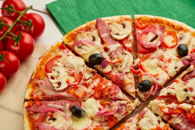 Pizza fraîchement cuite au four avec saucisses fumées, poivrons rouges, oignons et olives servis sur fond de bois avec sauce tomate et herbes Concept de livraison de nourriture Menu du restaurant