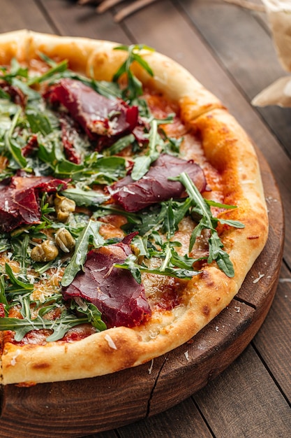 Pizza gourmande appétissante avec viande de cheval séchée et roquette