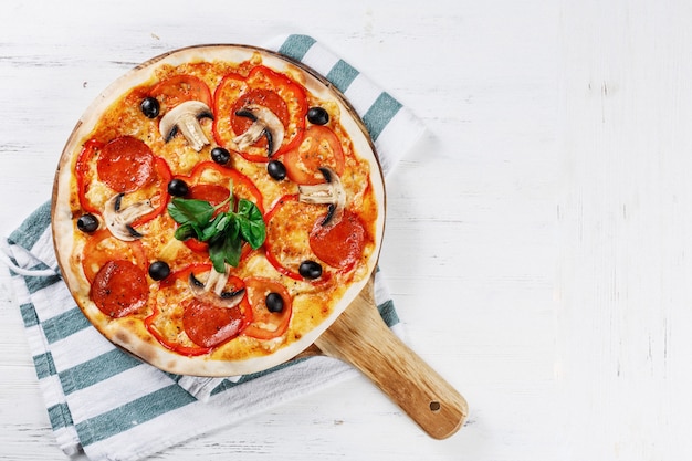 Pizza italienne aux champignons, basilic, tomate, olives et fromage