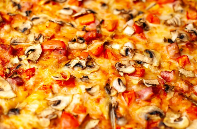 pizza italienne aux champignons, tomates et fromage sur bois