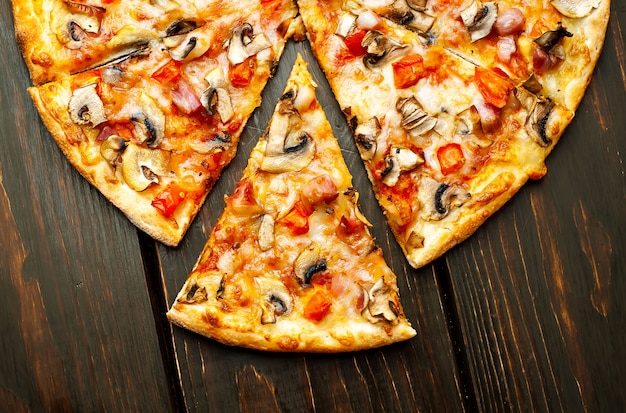 pizza italienne aux champignons, tomates et fromage sur bois