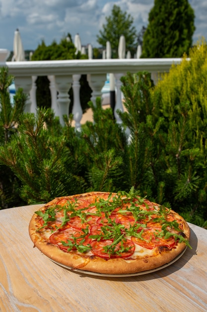 Pizza italienne aux herbes sur une table en bois