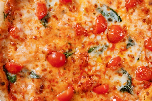 Pizza italienne aux tomates, épinards et fromage en gros plan Livraison de restauration rapide italienne