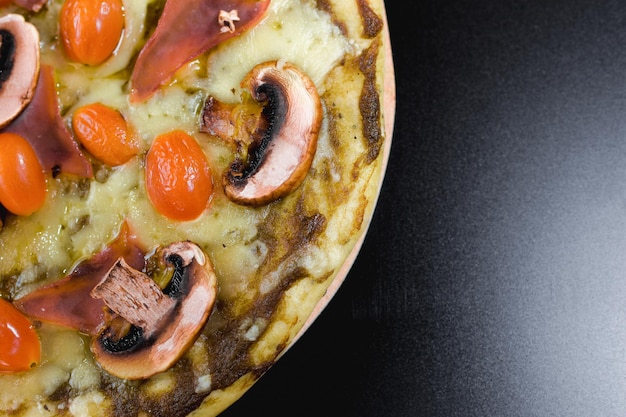 Pizza italienne à croûte mince avec champignons et petites tomates et fromage supplémentaire