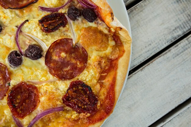 Pizza italienne dans une assiette sur une planche en bois