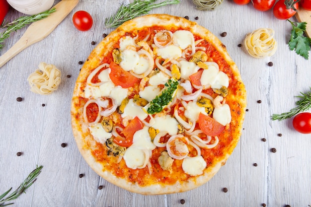 pizza italienne sur un fond en bois avec décoration autour