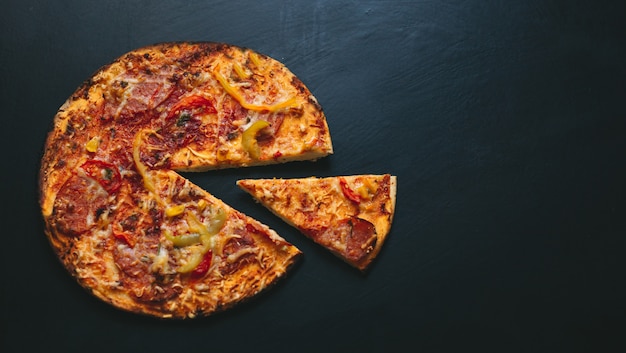 Pizza italienne sur fond noir avec vue de dessus. Espace pour le texte