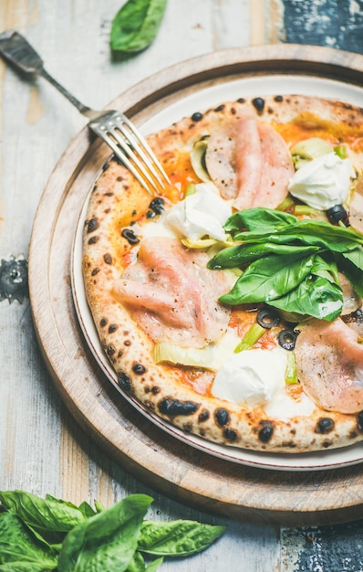 Pizza italienne fraîchement cuite au fromage à la crème d'artichauts au jambon