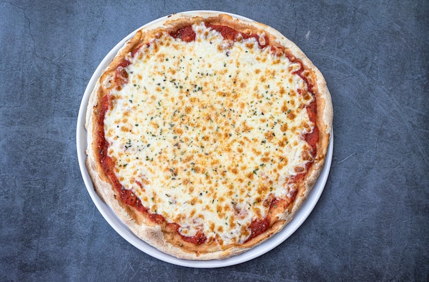 Pizza italienne Margherita au fromage et sauce tomate sur la table rustique Vue d'en hautv