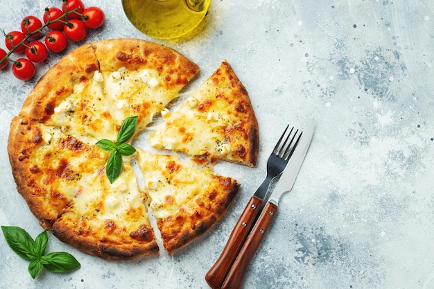 Photo pizza italienne à quatre fromages avec fromage étirable et basilic sur un fond en béton clair