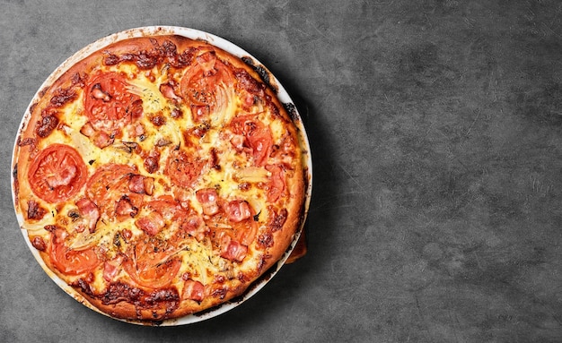 Pizza italienne traditionnelle aux champignons mozzarella tomates et bacon Disposition de la vue de dessus sur une table grise Espace libre pour votre texte Style campagnard