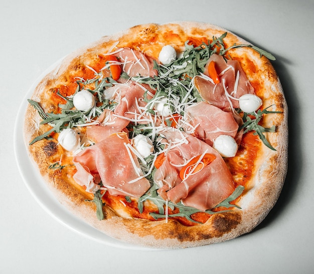 Pizza italienne traditionnelle avec jambon fromage mozzarella sur un concept de cuisine de restaurant table blanche