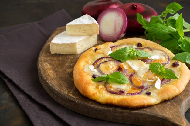 Pizza italienne traditionnelle avec oignons et basilic.