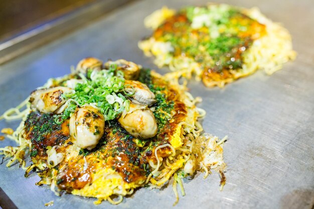 Pizza japonaise Okonomiyaki sur plaque chauffante