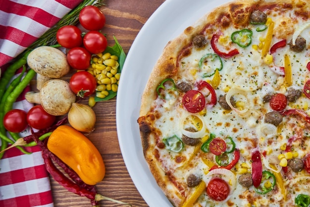 une pizza avec des légumes et des tomates sur une table.