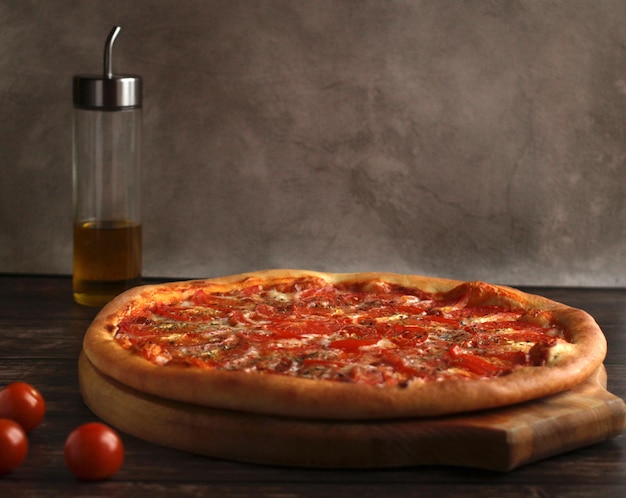 Pizza Margarita aux tomates, épices au fromage et huile d'olive sur fond sombre