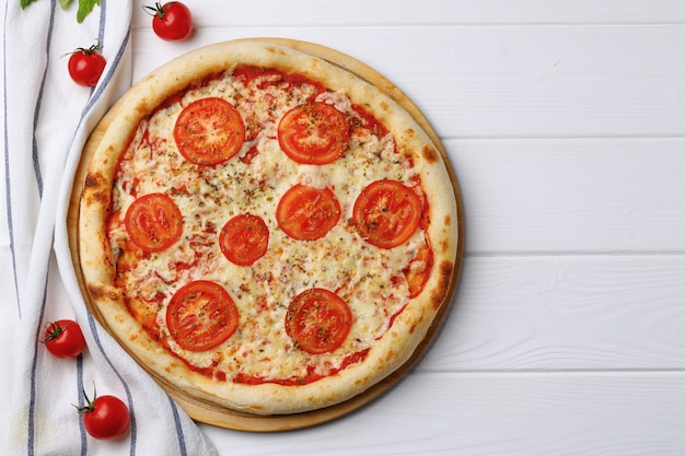 Pizza Margherita à bord sur table en bois blanc