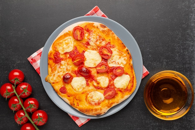 Pizza Margherita avec des ingrédients sur fond noir.