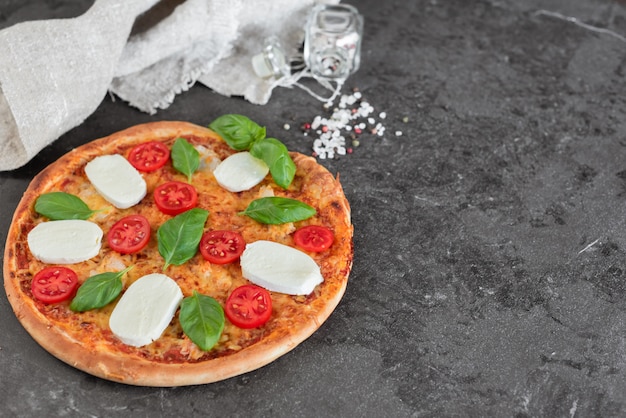 Pizza, nourriture, légume. Pizza de légumes, champignons et tomates sur un fond sombre