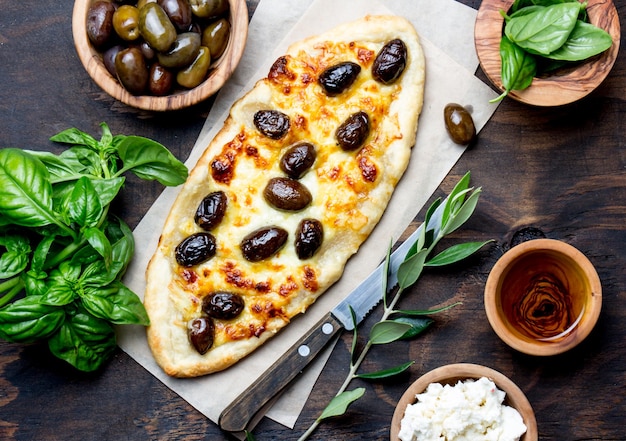 Pizza ovale faite maison avec olives entières et fromage Vue de dessus