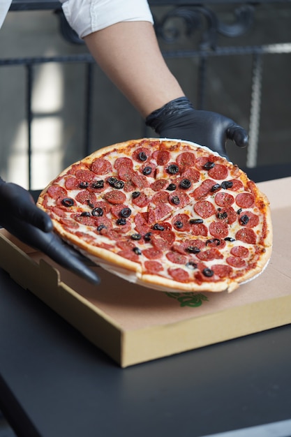Pizza pepperoni fraîchement préparée avec olive noire prête à livrer