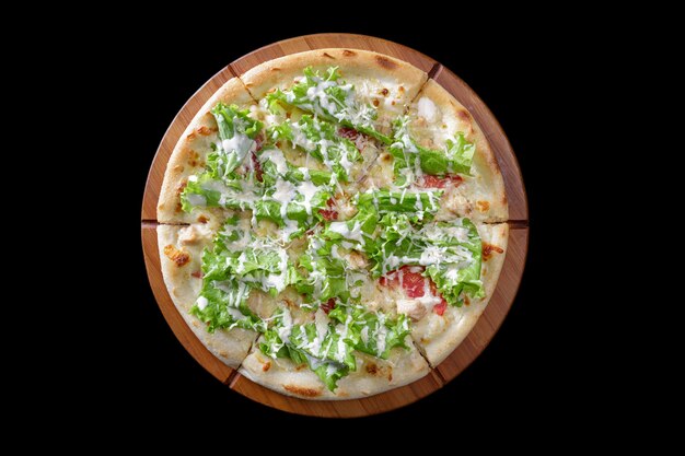 Pizza sur une planche de bois sur fond noir