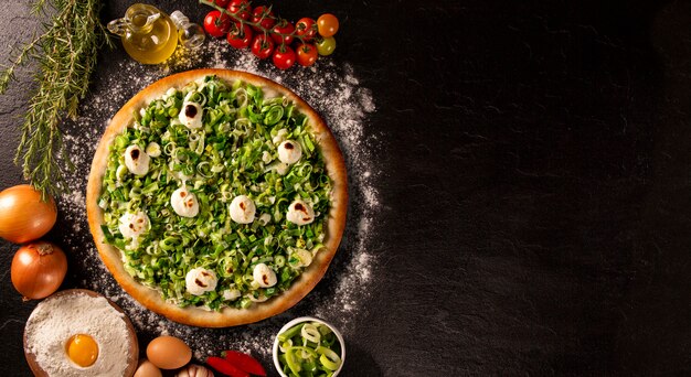 Pizza poireau et fromage à la crème sur béton noir