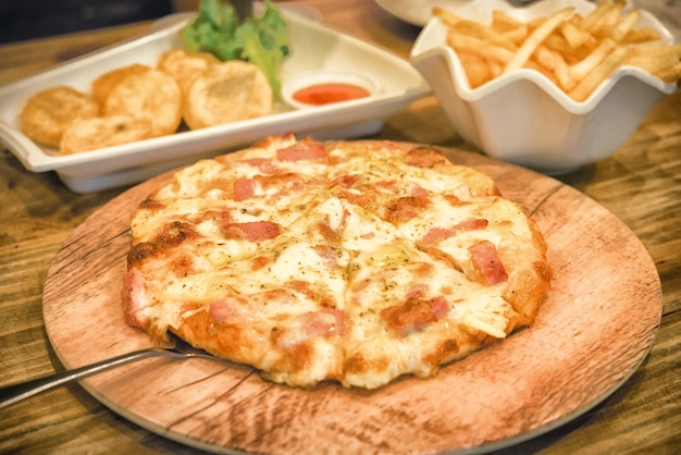 Photo pizza posée sur une assiette en bois