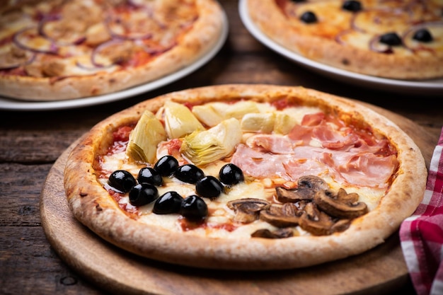 Pizza quatre saisons sur table en bois close up