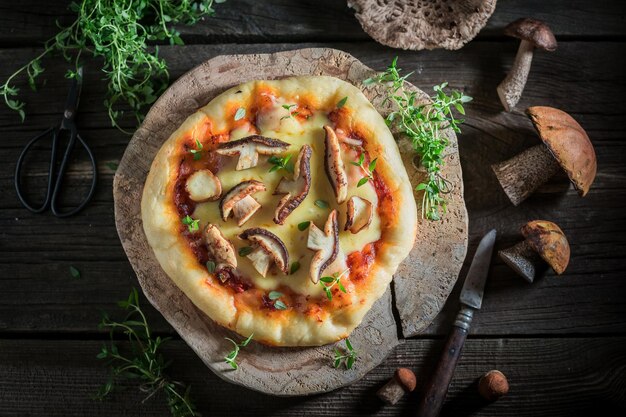 Pizza rustique faite maison sur une vieille table en bois