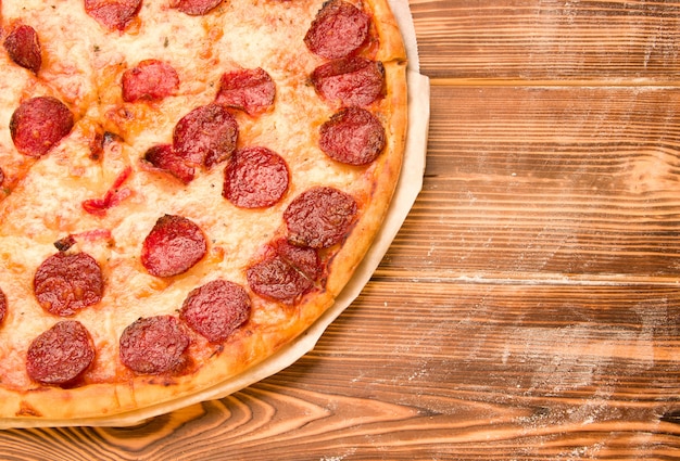 Pizza salami sur une table en bois