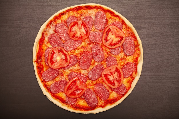 Pizza savoureuse avec divers ingrédients aromatisés sur fond noir