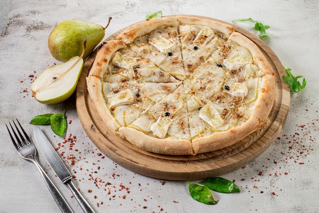 Pizza sucrée au brie aux poires sur fond de béton