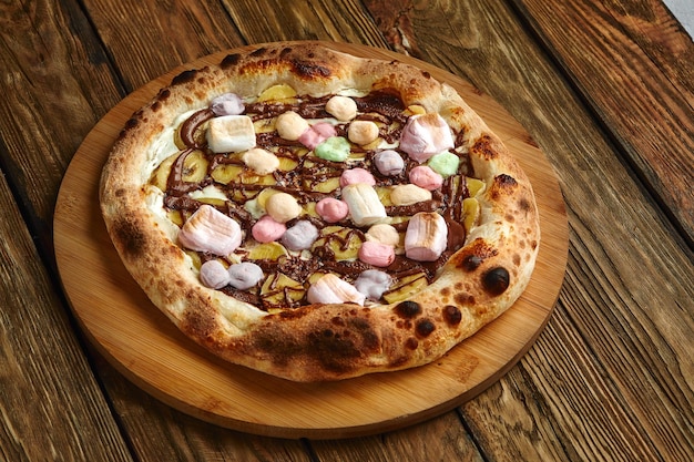 Pizza sucrée entière servie avec des guimauves et des bonbons