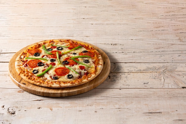 Pizza suprême traditionnelle sur table en bois rustique