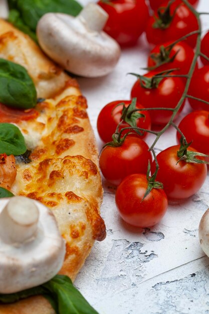 Pizza avec des tomates aux épinards et du fromage gorgonzola sur un fond clair