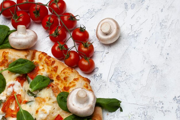 Photo pizza avec des tomates aux épinards et du fromage gorgonzola sur un fond clair